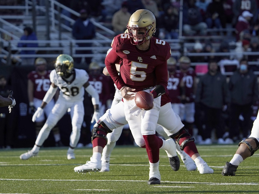 caption: Boston College quarterback Phil Jurkovec prepares to hand the ball off during a game earlier this season. The team had to withdraw from the Military Bowl because of the pandemic.