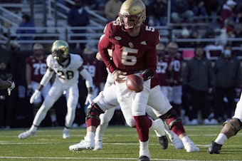 caption: Boston College quarterback Phil Jurkovec prepares to hand the ball off during a game earlier this season. The team had to withdraw from the Military Bowl because of the pandemic.