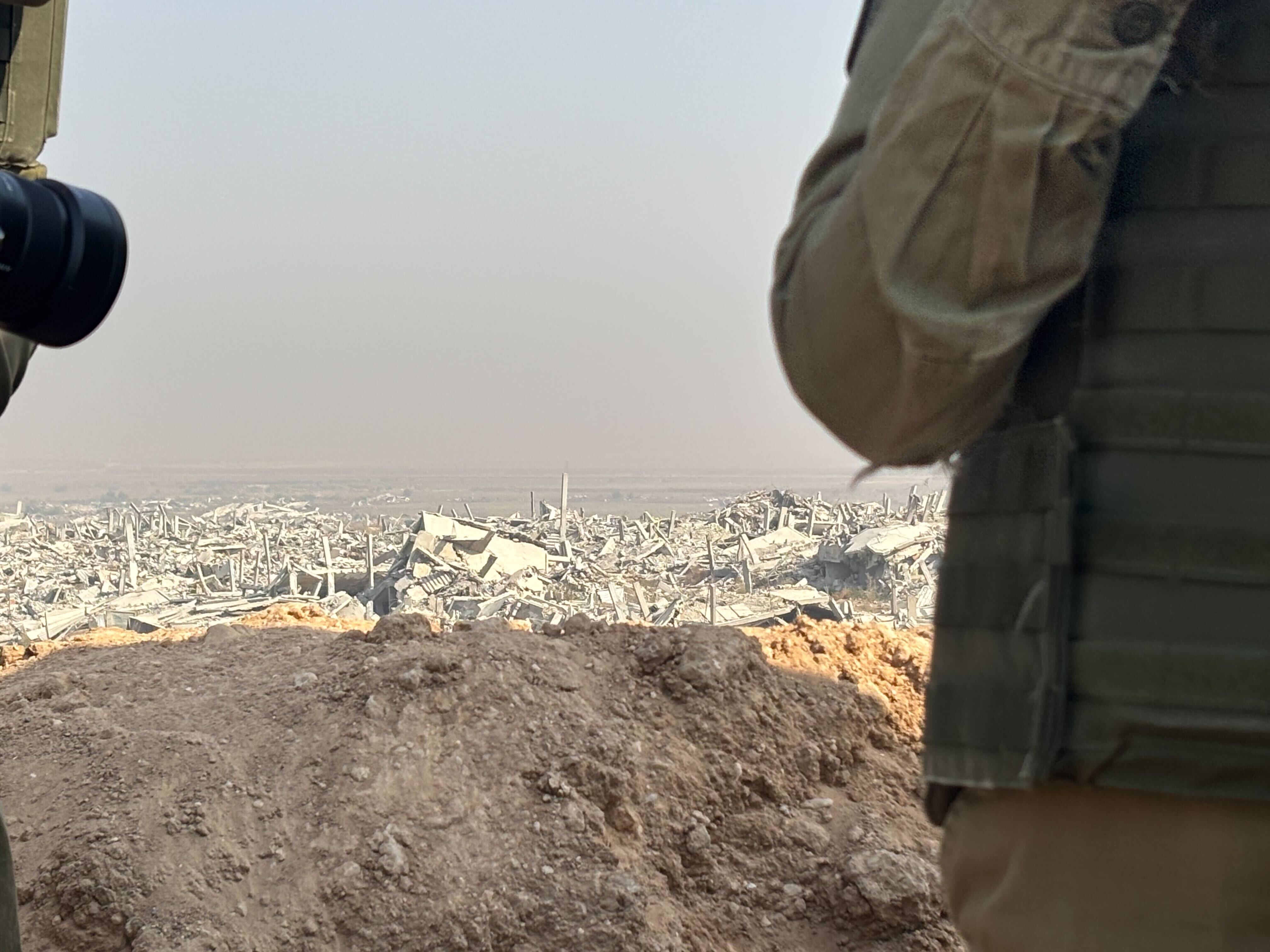 caption: An Israeli military outpost in Gaza overlooks destruction in the Shujaiya neighborhood on the outskirts of Gaza City.