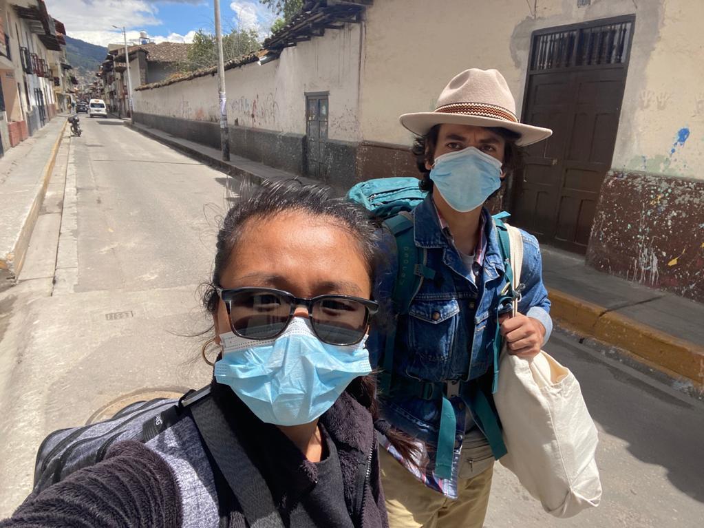 caption: Pu Ying Huang (left) and Dylan Baddour walk along an empty street in Cajamarca, Peru, on March 18, while they were moving from a small hotel room to an Airbnb to ride out the country's 15-day lockdown.