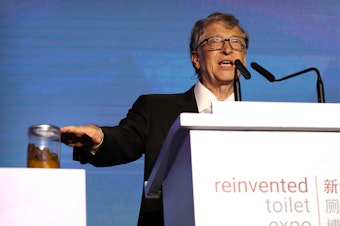 caption: Bill Gates, co-founder of the Bill & Melinda Gates Foundation, gestures to a jar of human feces as he speaks at the Reinvented Toilet Expo in Beijing on November 6.