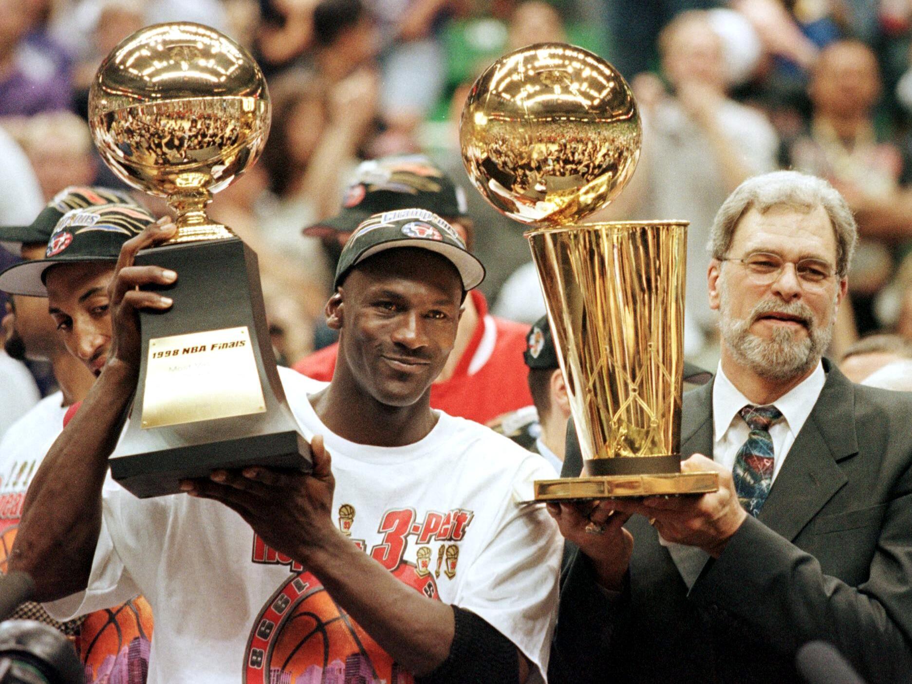 caption: Michael Jordan and Chicago Bulls head coach Phil Jackson celebrate the team's sixth NBA championship on June 14, 1998.
