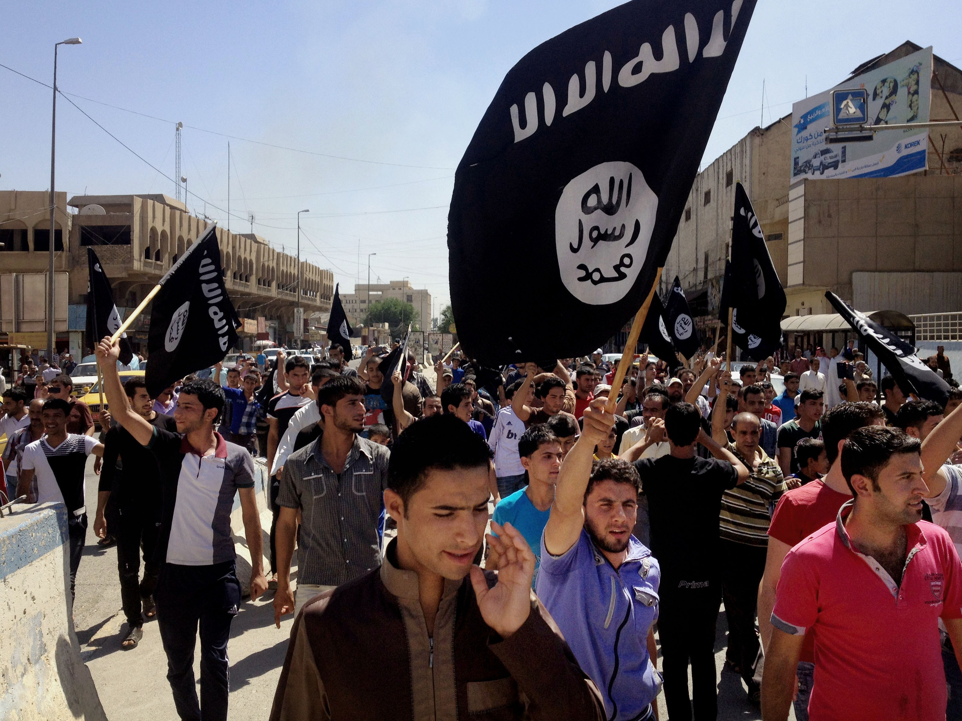 caption: Demonstrators chant pro-Islamic State group slogans as they carry the group's flags in front of the provincial government headquarters in Mosul, Iraq, on June 16, 2014.