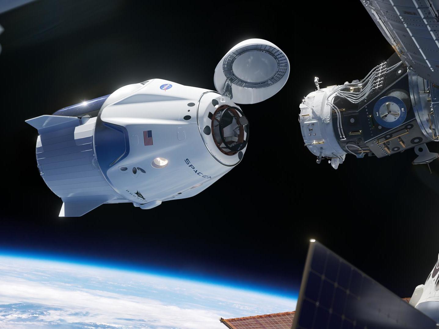caption: In this illustration, SpaceX's Crew Dragon approaches the International Space Station for docking. The capsule has room to carry seven astronauts.