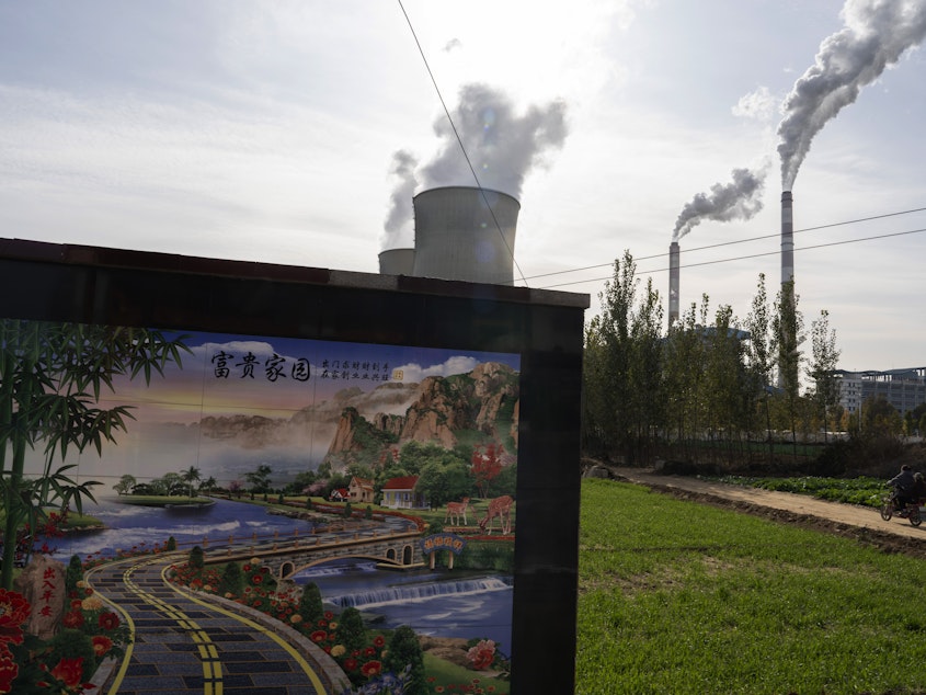 caption: A resident rides past the Guohua Power Station in northern China's Hebei province. China and the U.S. have pledged to accelerate their efforts to address climate change ahead of a major U.N. meeting on the issue.