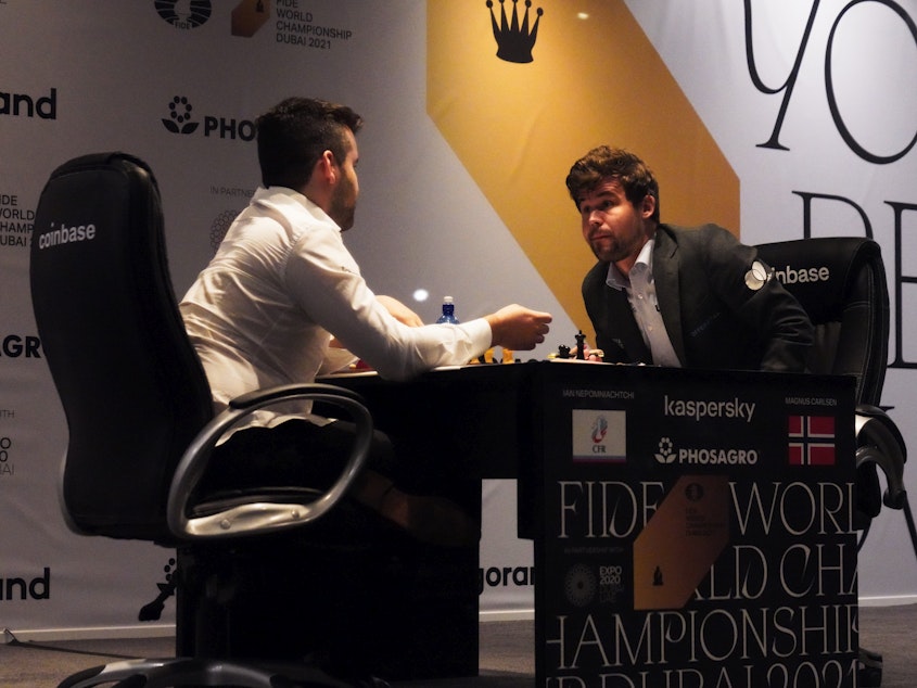 caption: Ian Nepomniachtchi of Russia (left) and Magnus Carlsen of Norway talk after Carlsen won the FIDE World Championship in 2021. FIDE has banned competitions in Russia and Belarus in response to Russia's invasion of Ukraine.