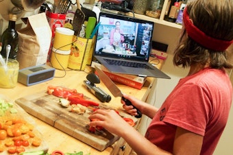 caption: Wiley James, 10, prepares a meal as part of an online cooking camp run by a chef in Austin, Texas.