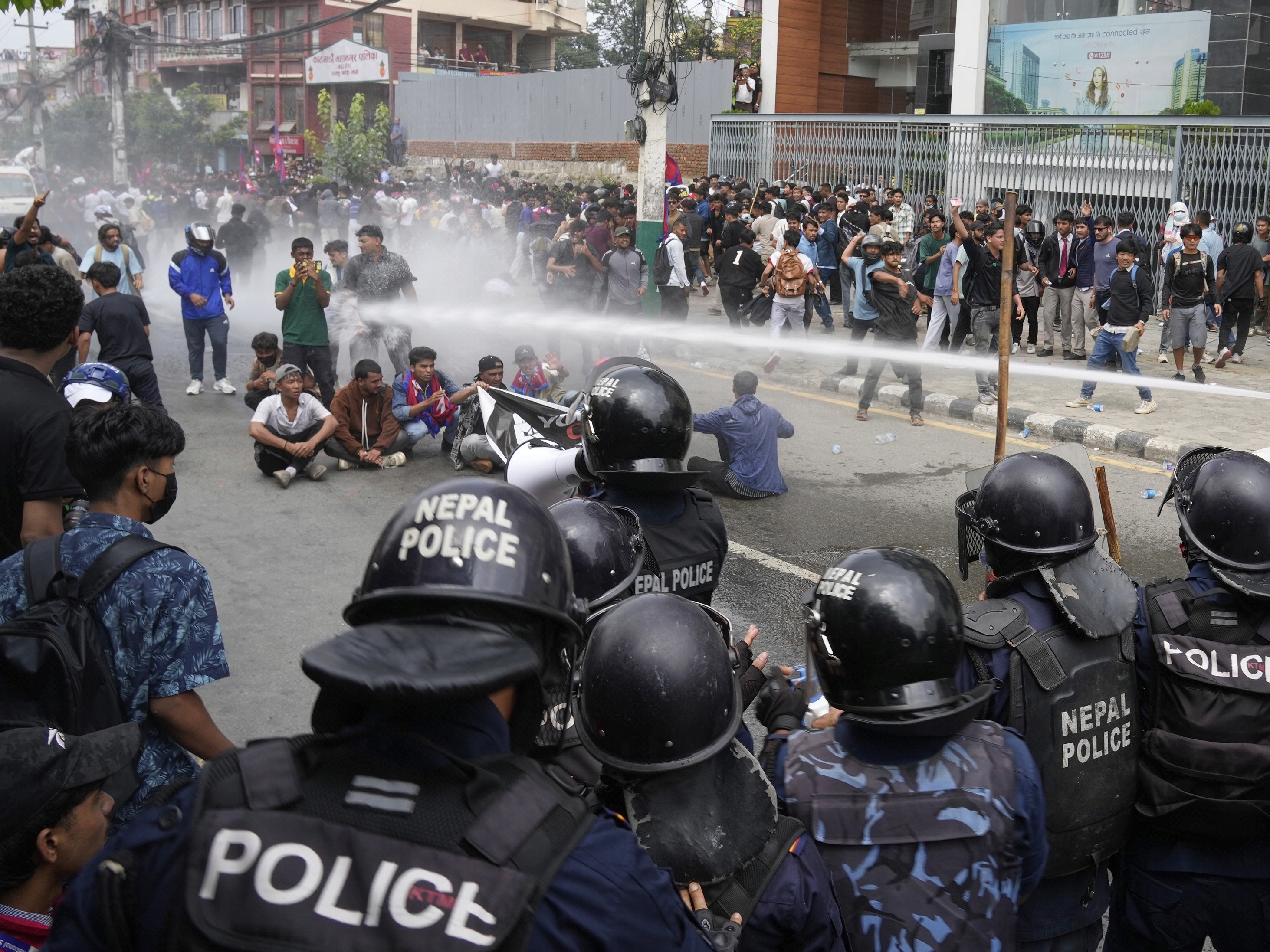 caption: Riot police use a water cannon on protesters outside Parliament in Kathmandu, Nepal, Monday, Sept. 8, 2025.