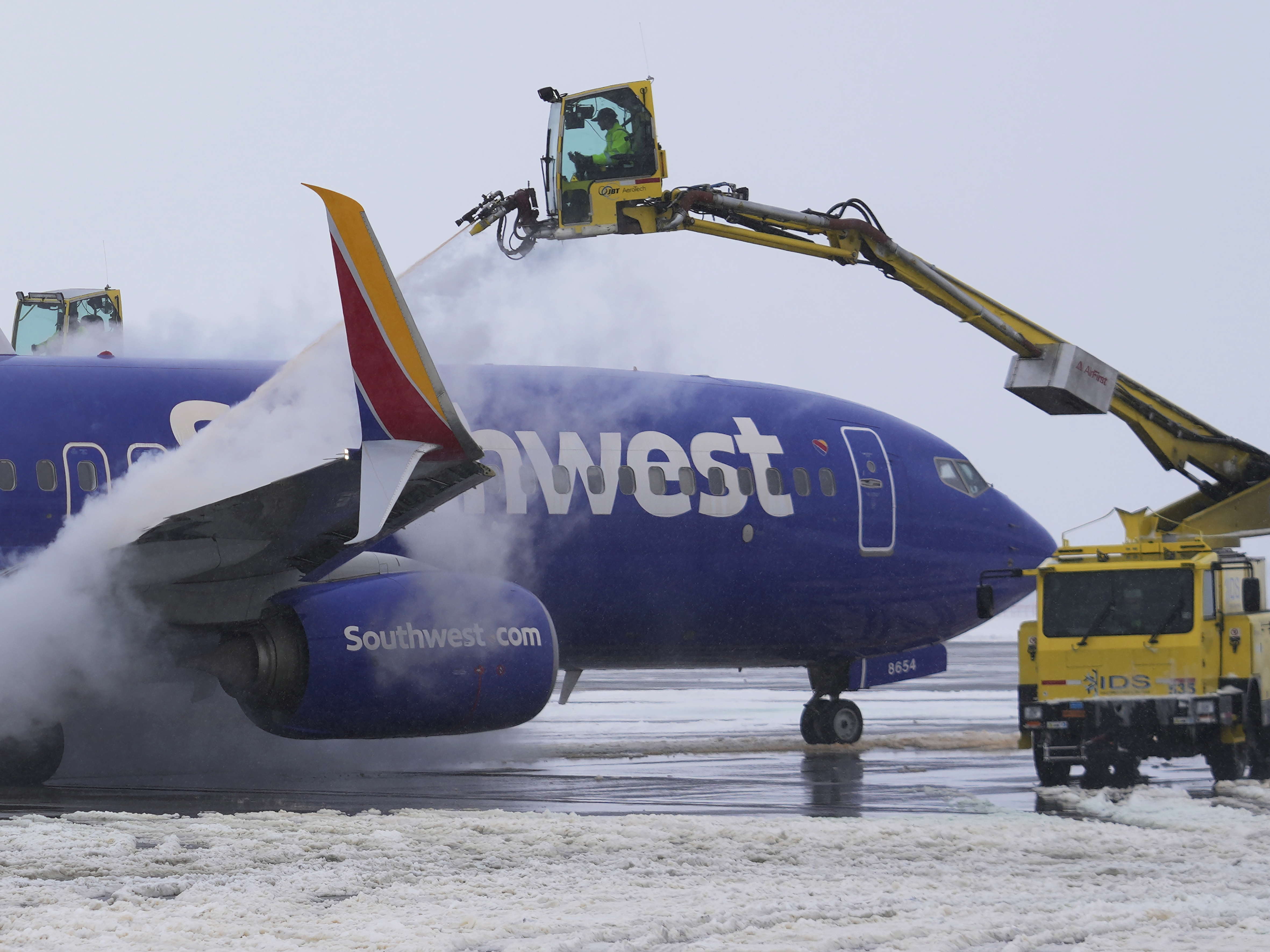 caption: A Southwest Airlines Boeing 737 is de-iced before takeoff at Salt Lake City International Airport on Feb. 22, 2023. The wings, fuselage and tail must be de-iced before it can fly whenever there's snow, ice or frost.