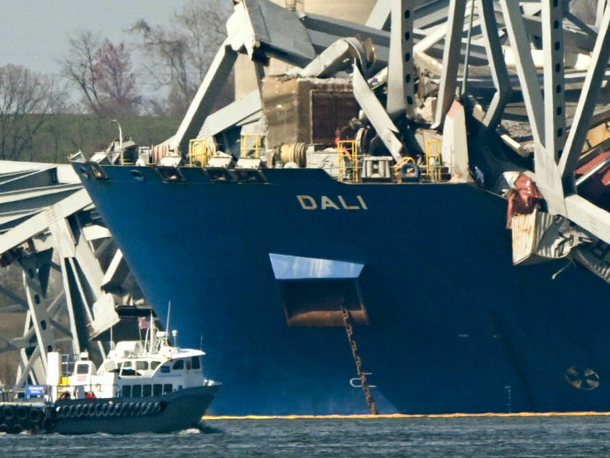 caption: The wreckage of the collapsed Francis Scott Key Bridge lies on top of the container ship Dali in Baltimore, Maryland, on March 29, 2024.