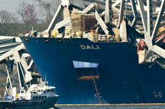 caption: The wreckage of the collapsed Francis Scott Key Bridge lies on top of the container ship Dali in Baltimore, Maryland, on March 29, 2024.