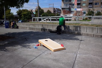 caption: A corn hole game installed by the city of Seattle at Ballard Commons park. It is maintained by a "concierge" whose job is to build a comfortable atmosphere in the park. 