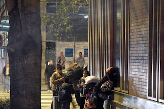 caption: Homeless families outside a shelter in downtown Seattle.