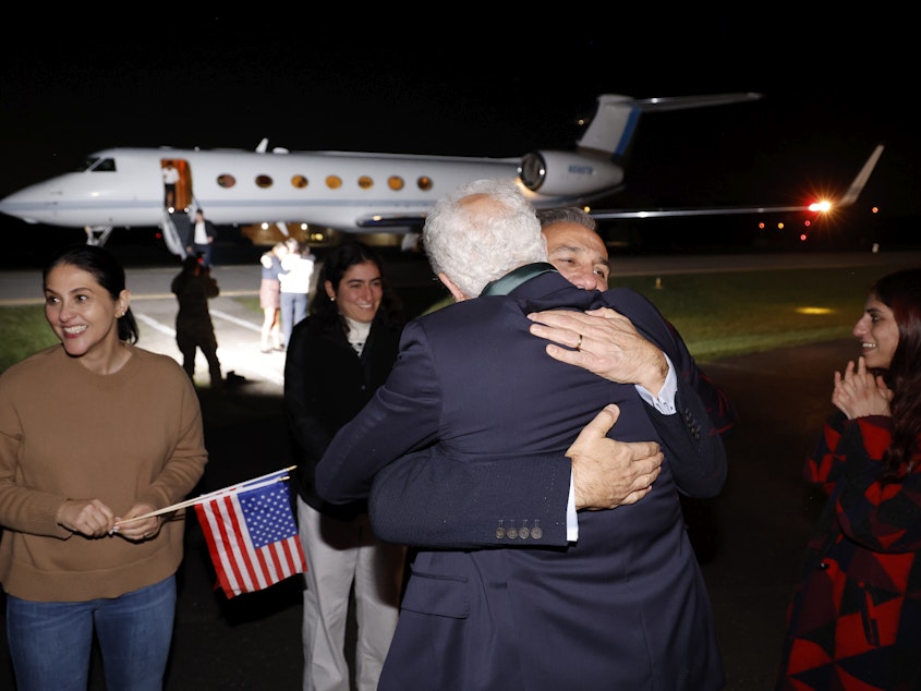 caption: Family members embrace freed Americans Siamak Namazi, Morad Tahbaz and Emad Shargi, as well as two returnees whose names have not been released by the U.S. government, who were released in a prisoner swap deal between U.S and Iran, as they arrive at Davison Army Airfield on Tuesday at Fort Belvoir, Va.