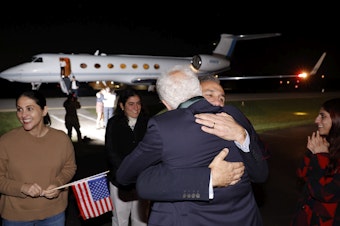 caption: Family members embrace freed Americans Siamak Namazi, Morad Tahbaz and Emad Shargi, as well as two returnees whose names have not been released by the U.S. government, who were released in a prisoner swap deal between U.S and Iran, as they arrive at Davison Army Airfield on Tuesday at Fort Belvoir, Va.