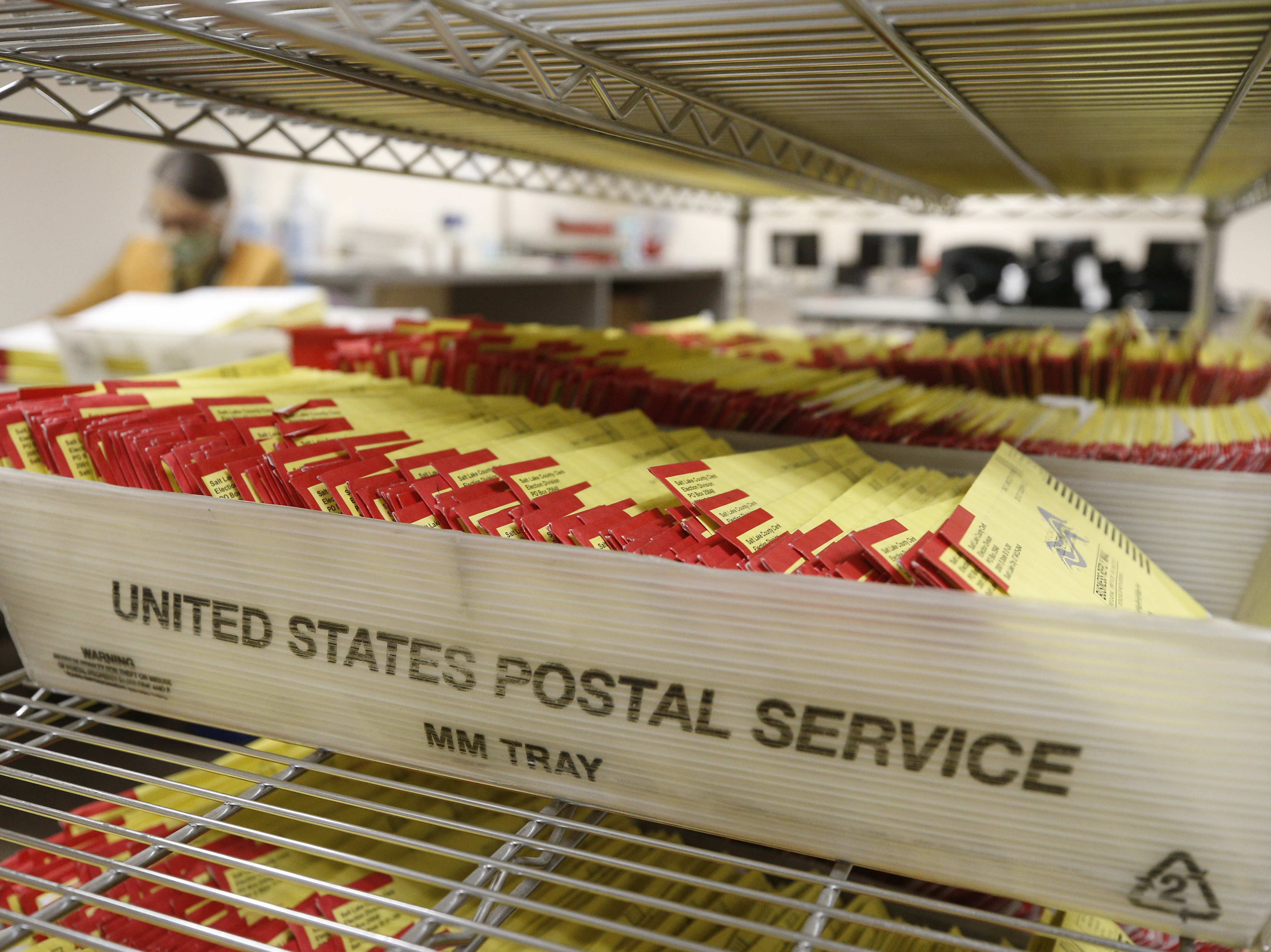 caption: Mail-in ballots waiting to be processed by election workers in Salt Lake City, Utah.