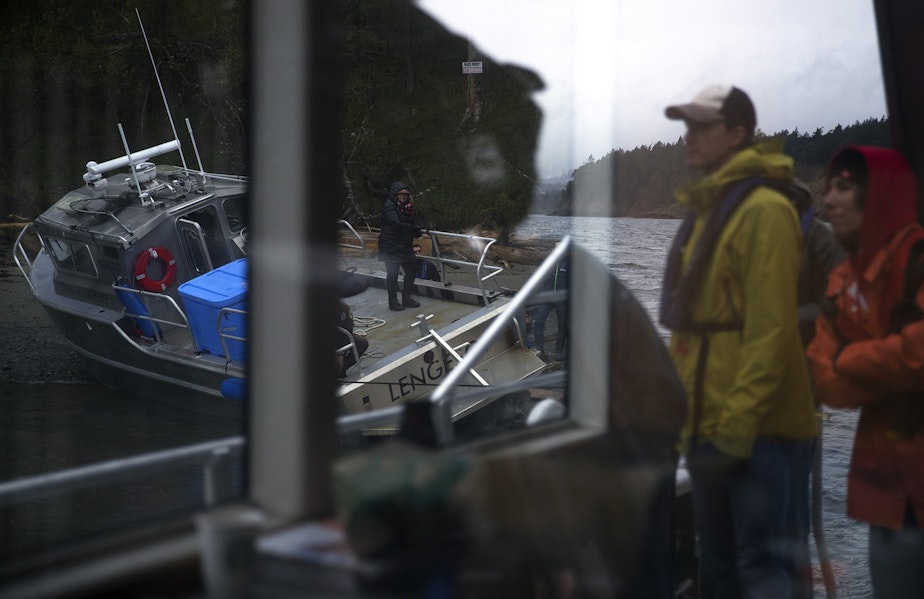 caption: Jake Bullinger and Julie Trimingham, right, look on as attempts are made to free the Lummi Nation police boat after it was briefly grounded on Wednesday, April 10, 2019, on Henry Island. 