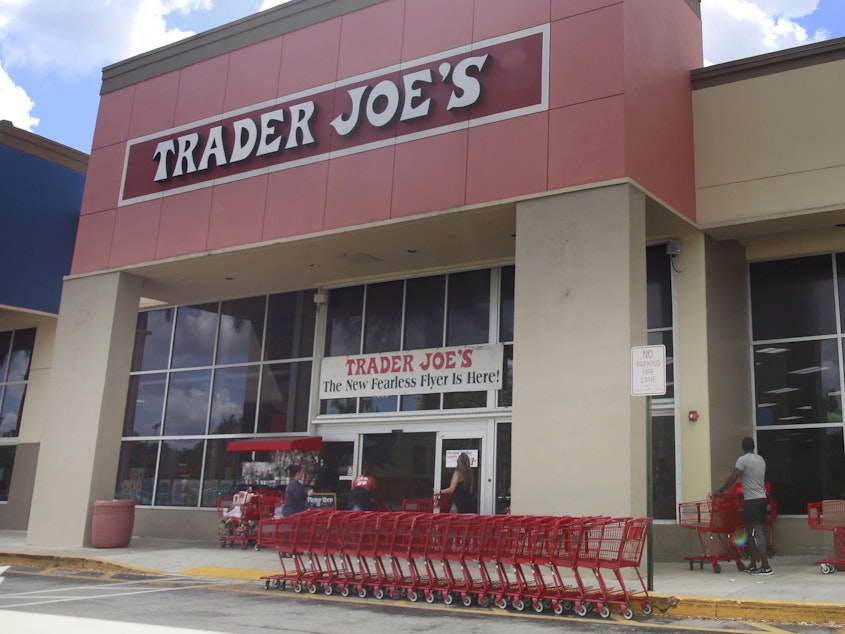 caption: People stand in line waiting to enter Trader Joe's to buy groceries in Pembroke Pines, Fla., on March 24, 2020.