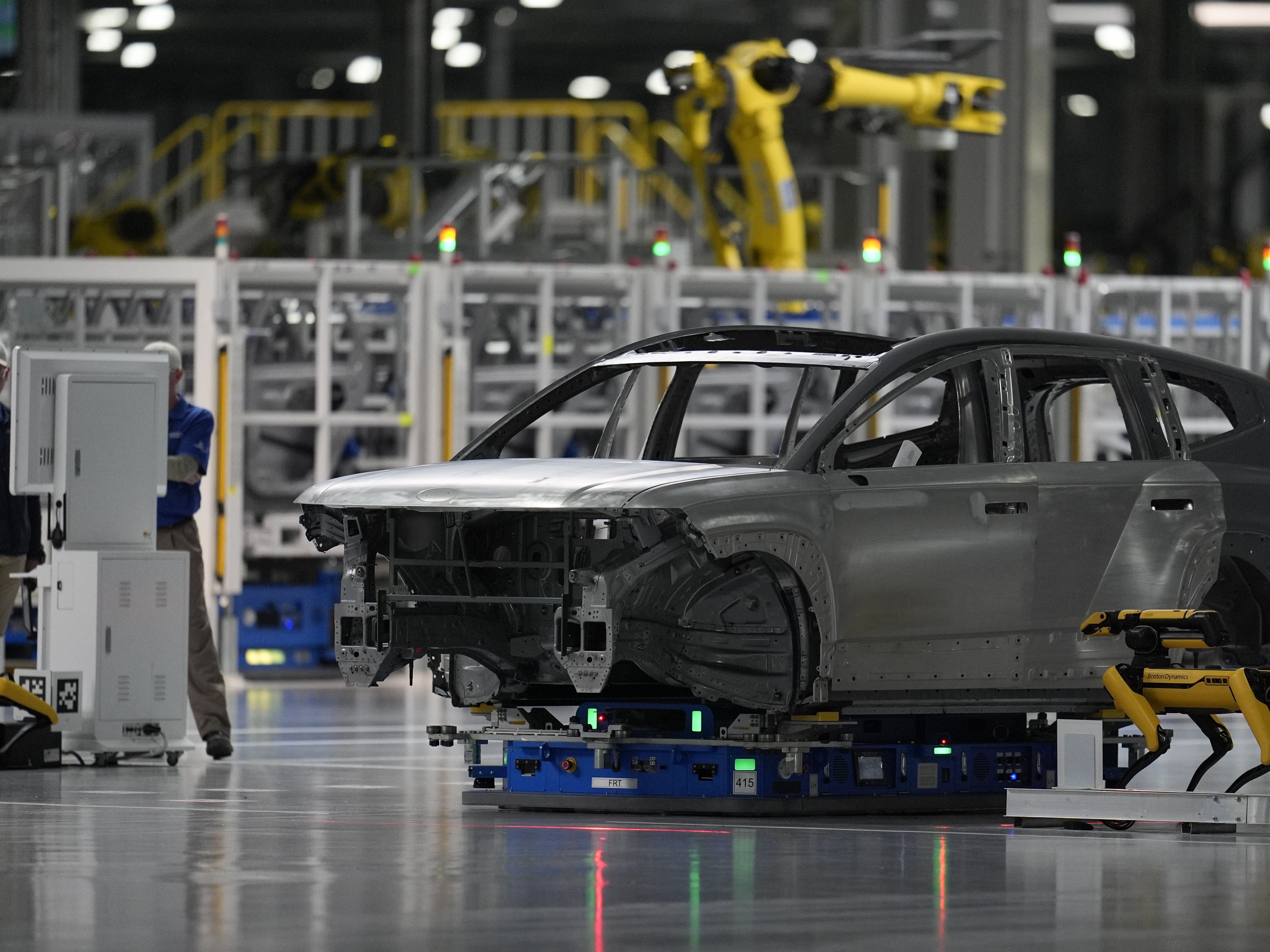 caption: A Boston Dynamics robot "dog" inspects a vehicle body as part of quality control during a media tour at the Hyundai Motor Group Metaplant America in Ellabell, Ga., on March 26. During the grand opening ceremony for the plant, which actually produced its first vehicle in October, company executives and Georgia politicians did not emphasize — or even mention — that the plant produces electric vehicles.