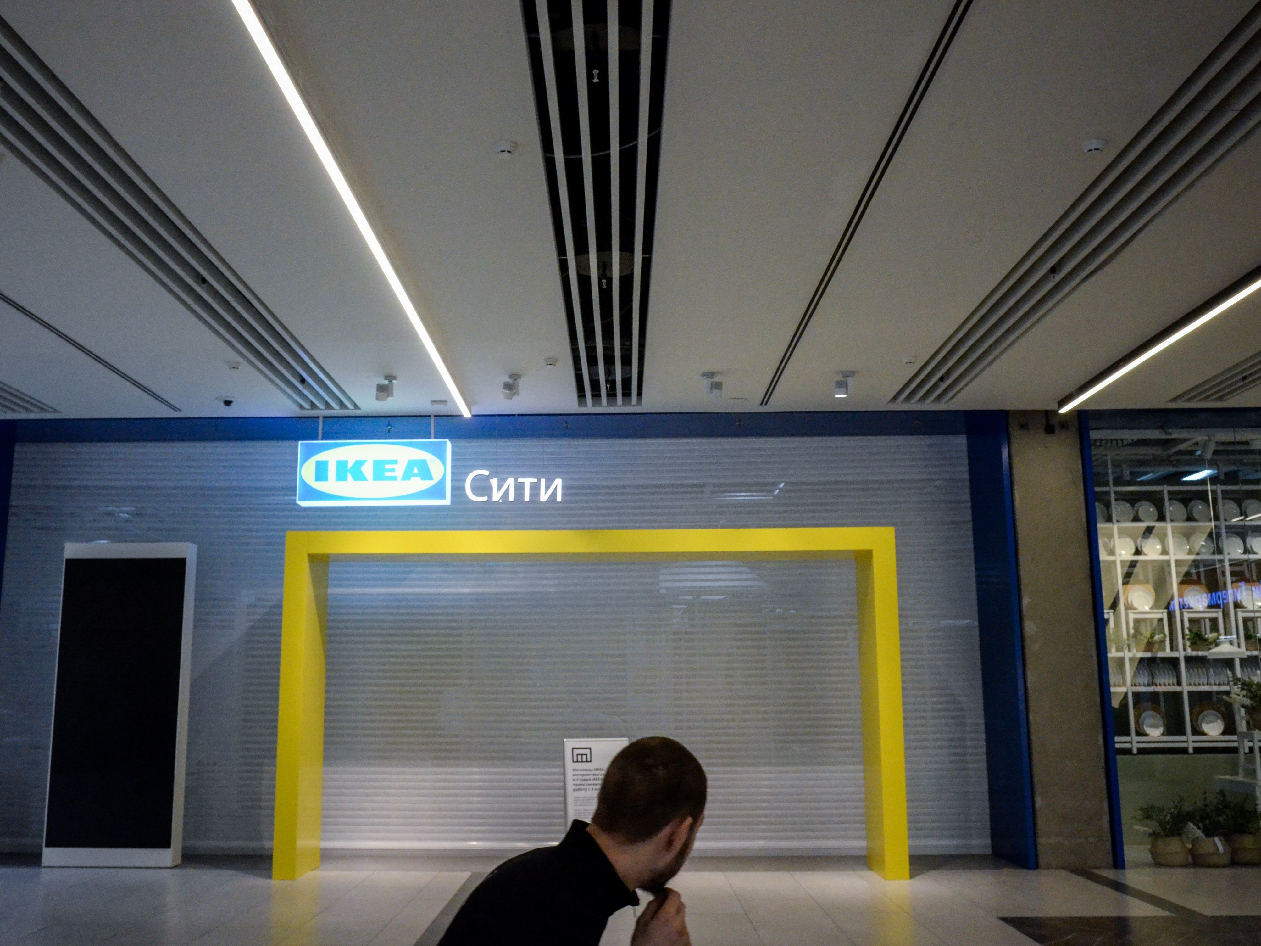 caption: A man walks past the closed Ikea shop at a Moscow shopping mall on April 11.