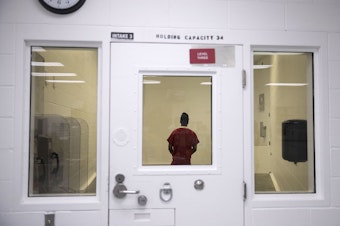 caption: An individual who is detained is shown in one of the intake holding areas on Tuesday, September 10, 2019, at the Northwest Detention Center, renamed the Northwest ICE Processing Center, in Tacoma.