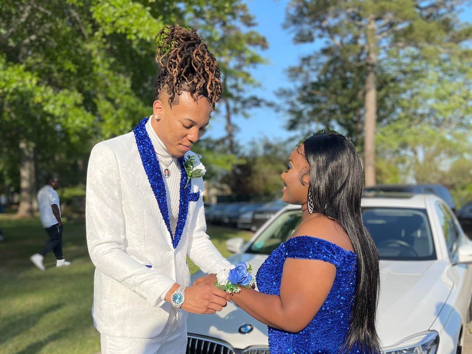 caption: Cameron Frazier and Gabrielle Cistrunk. Cameron wore an embroidered white suit, with blue sequins on the lapel and the bottom of the legs. His shoes featured blue sequin trim.