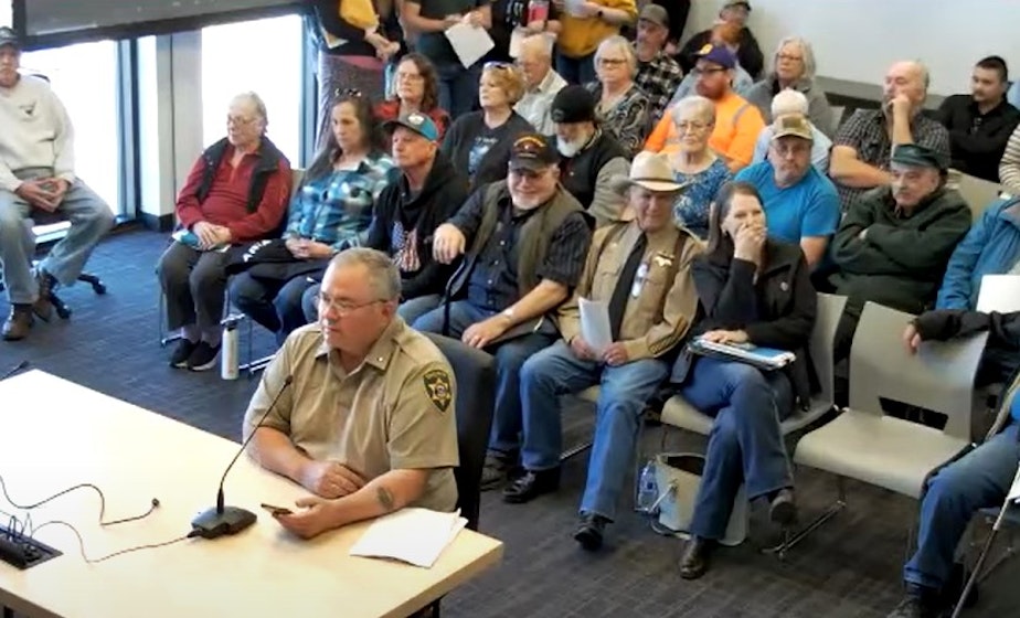 caption: Klickitat County jail chief Loren Culp addresses commissioners on April 2, 2024 in opposition to the proposed closure. Sheriff Bob Songer sits behind him. 