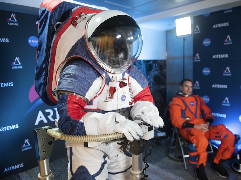 caption: The two NASA spacesuit prototypes, one for exploring the surface of the moon's South Pole (left) and one for launch and reentry aboard the agency's Orion spacecraft, won't become a reality in time for a planned 2024 mission.