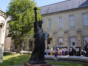 caption: A mini replica of the French-designed Statue of Liberty will reach the U.S. on July 1. Here, the statue awaits its move in Paris on Monday.