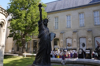 caption: A mini replica of the French-designed Statue of Liberty will reach the U.S. on July 1. Here, the statue awaits its move in Paris on Monday.