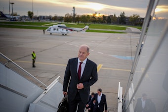 caption: German Chancellor Olaf Scholz arrives at Berlin-Brandenburg Airport for his flight to China on Thursday.
