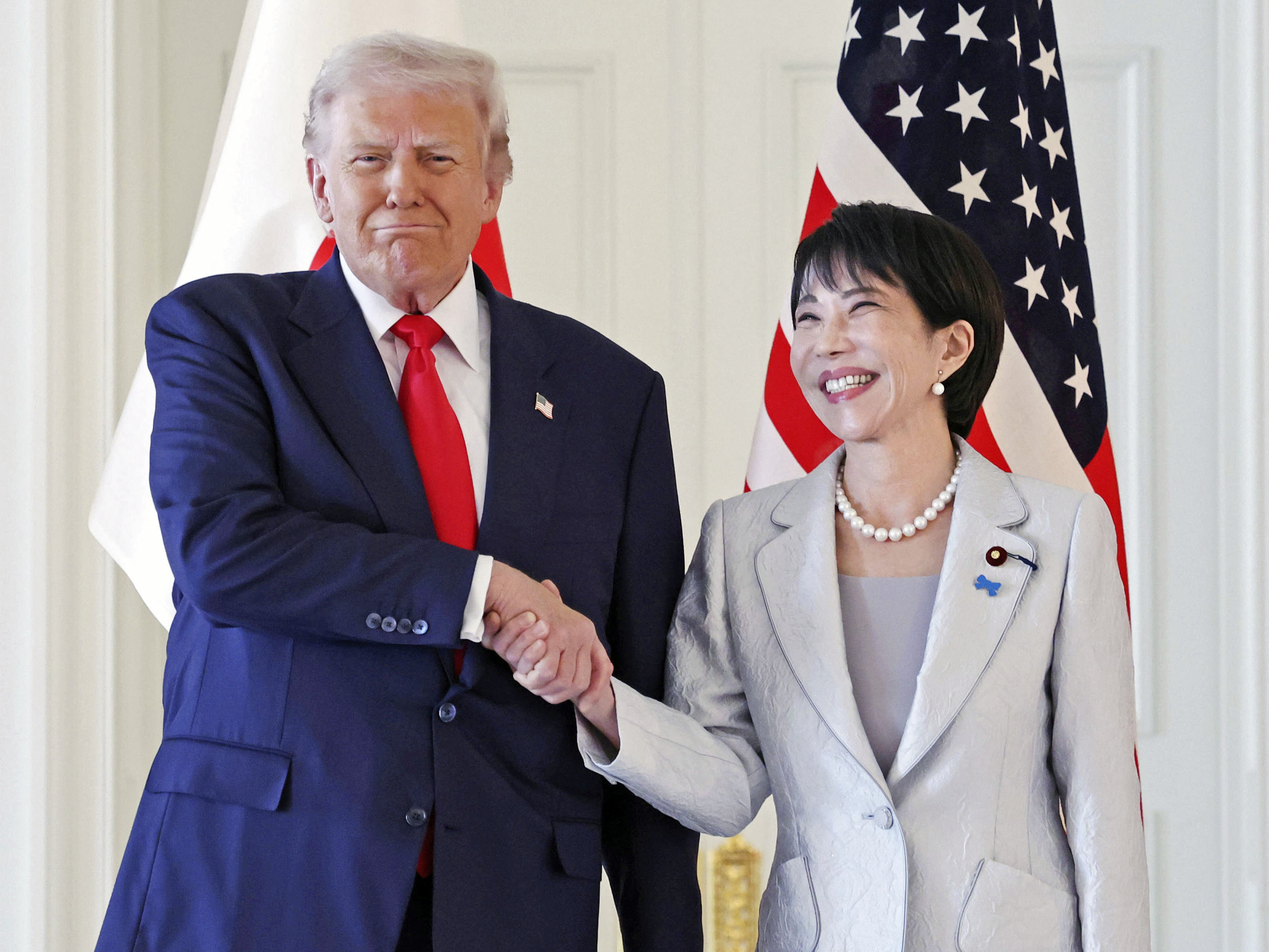 caption: President Donald Trump, left, and Japanese Prime Minister Sanae Takaichi shake hands before their summit talk at Akasaka Palace in Tokyo, on Tuesday.