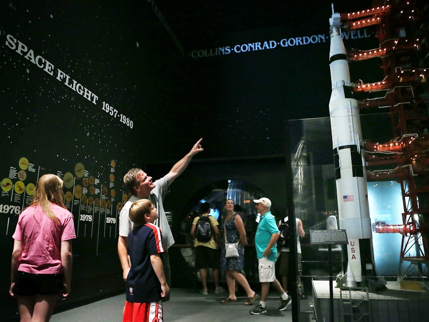 caption: Visitors look at a model of a Saturn V rocket and its launch umbilical tower, which were used during the Apollo moon-landing program, at the Smithsonian National Air and Space Museum in Washington, D.C. Fifty years ago this July 20, Neil Armstrong and Buzz Aldrin became the first humans to walk on the moon.
