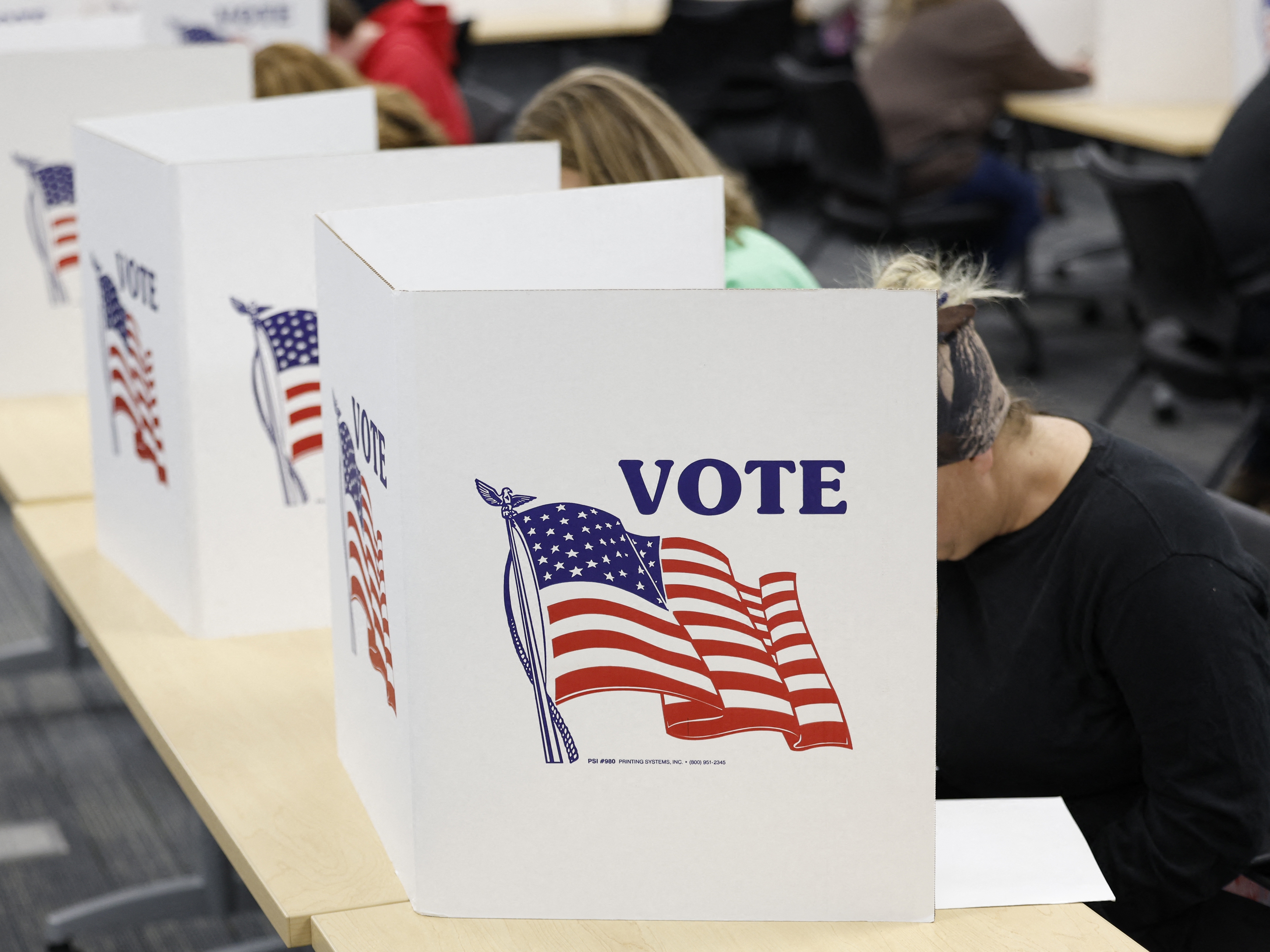caption: A man casts his ballot during early voting in Waukesha, Wis., on March 18.