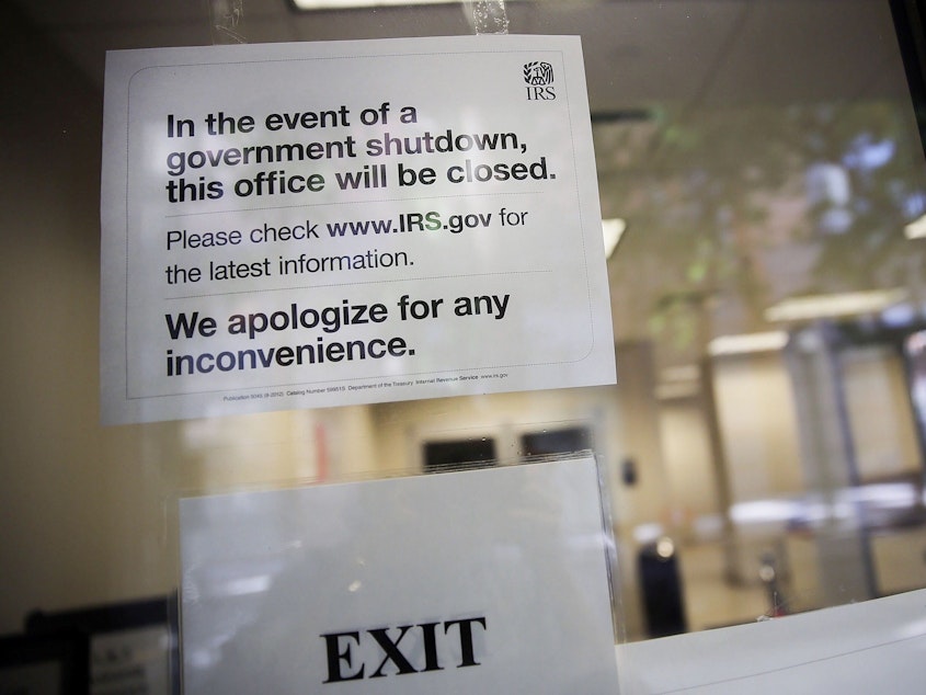 caption: A sign is posted in the window of an IRS office in Brooklyn notifying that the office is closed due to the government shutdown on October 1, 2013 in New York City.