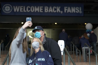 caption: A group of fans takes a selfie after entering T-Mobile Park for the Seattle Mariners opening-day baseball game against the San Francisco Giants, Thursday, April 1, 2021, in Seattle. 