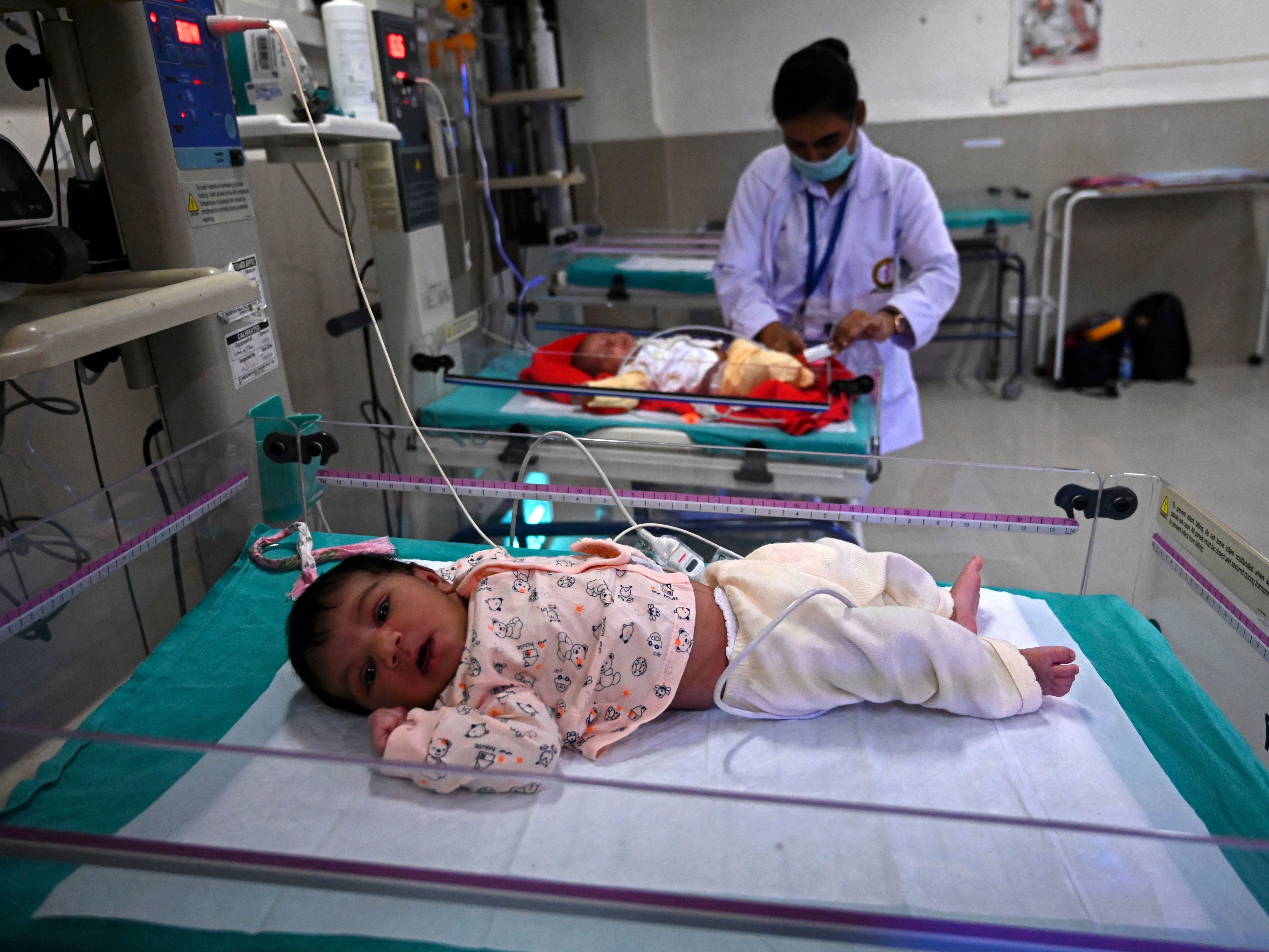 caption: The population of Earth will hit 8 billion on Nov. 15, according to predictions by the United Nations Population Fund. And next year, India is expected to surpass China as the most populous country. In this photo, taken on Oct. 13, newborn babies rest inside a newborn care unit at a hospital in Amritsar.