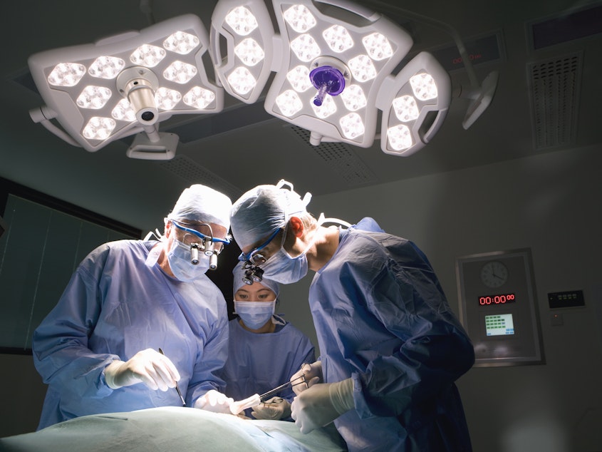 caption: The common practice of double-booking a lead surgeon's time and letting junior physicians supervise and complete some parts of a surgery is safe for most patients, a study of more than 60,000 operations finds. But there may be a small added risk for a subset of patients.