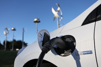 caption: An electric vehicle gets its battery recharged at a charge station in San Francisco on March 9. The Biden administration is spending $5 billion to build a network of chargers in a bid to get more people to buy electric cars.