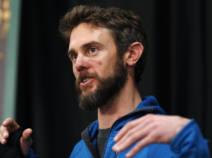 caption: Travis Kauffman responds to questions during a news conference Thursday about his encounter with a mountain lion while running a trail just west of Fort Collins, Colo., this month.