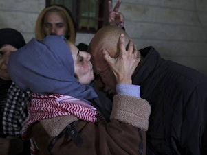 caption: Newly freed Palestinian prisoner Lamees Abu Arqub kisses her father after Palestinians were freed from Israeli jails in exchange for Hamas hostages held in Gaza, in the village of Dura in the occupied West Bank on Tuesday.
