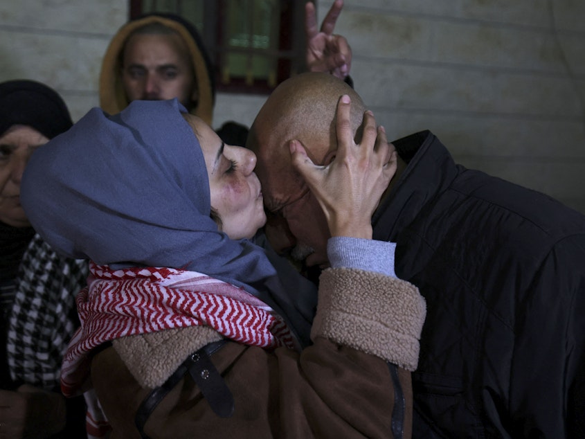 caption: Newly freed Palestinian prisoner Lamees Abu Arqub kisses her father after Palestinians were freed from Israeli jails in exchange for Hamas hostages held in Gaza, in the village of Dura in the occupied West Bank on Tuesday.