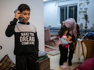 caption: Ibrahim, 12, speaks to his grandmother, who lives in Gaza, from his home in Ramallah in the Israeli-occupied West Bank on Jan. 31. The family did not want to use their full names out of fear of reprisals from Israeli authorities.