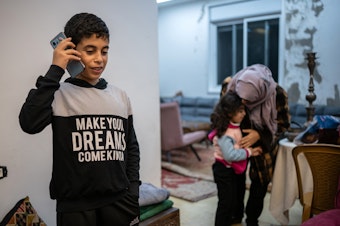 caption: Ibrahim, 12, speaks to his grandmother, who lives in Gaza, from his home in Ramallah in the Israeli-occupied West Bank on Jan. 31. The family did not want to use their full names out of fear of reprisals from Israeli authorities.