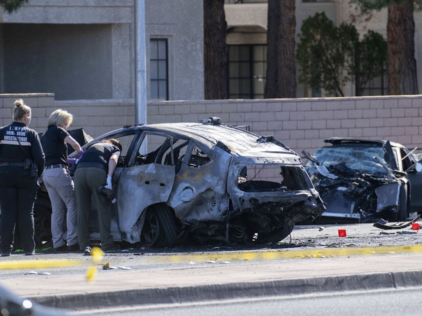 caption: Las Vegas Metro Police investigators work at the scene of a fatal crash Tuesday. Police say Las Vegas Raiders wide receiver Henry Ruggs III was involved in a fiery crash that left a woman dead and Ruggs and his female passenger injured.
