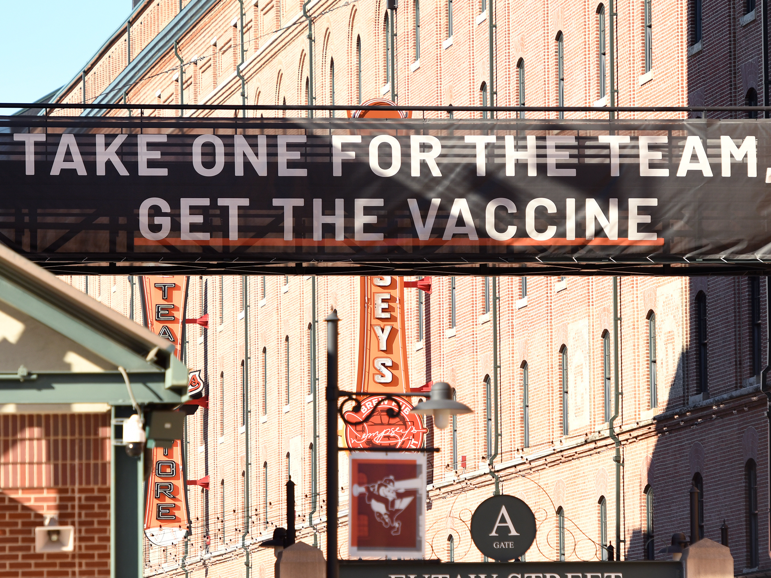 caption: A sign outside Camden Yards in Baltimore, Maryland, encourages people to get a COVID-19 vaccine.