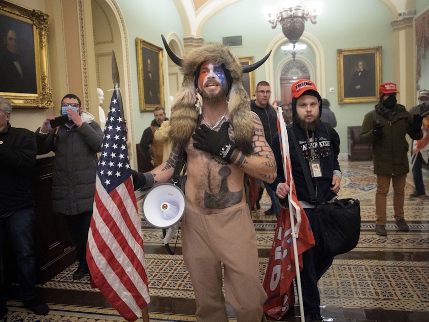 caption: Jacob Chansley, the self-styled "QAnon shaman," confronts U.S. Capitol Police officers during the Jan. 6 insurrection.