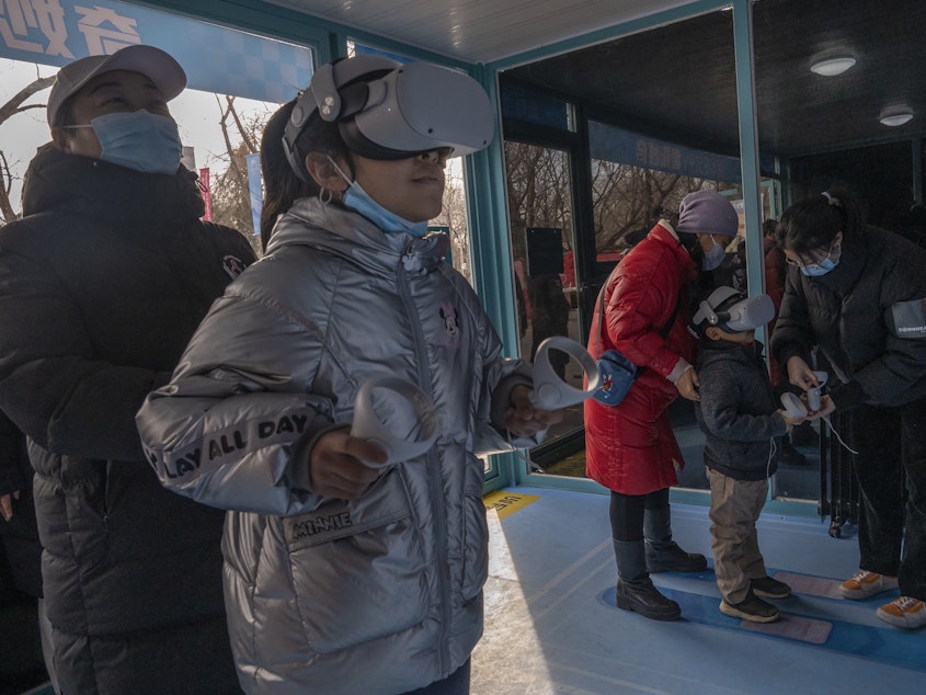 caption: Children play a virtual reality game a Beijing 2022 Winter Olympics Live Site set up on February 07, 2022 in Beijing, China.