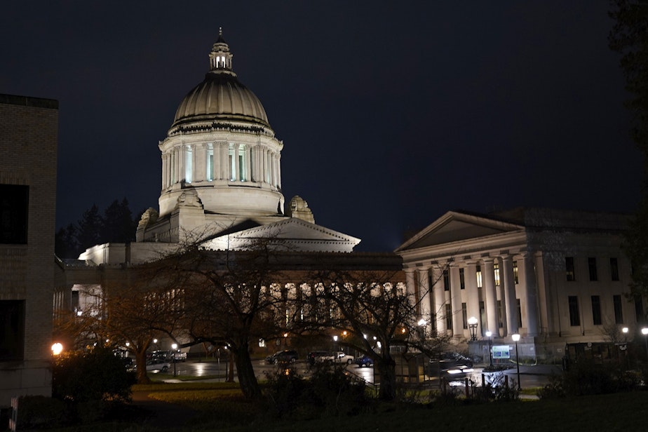 caption: The Legislative Building, left, stands at night on Thursday, Nov. 12, 2020, at the Capitol in Olympia, Wash. 