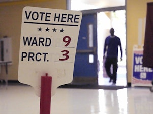 caption: A voter enters the Dr. Martin Luther King Jr. Charter Elementary School in New Orleans to cast a ballot in the 2022 elections.